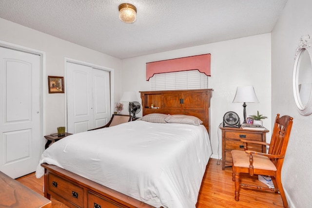 167 W Quincy Ave, Fresno, CA 93711 - bedroom featuring a textured ceiling, light wood-type flooring, baseboards, and a closet