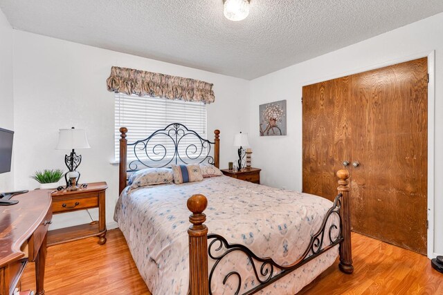167 W Quincy Ave, Fresno, CA 93711 - bedroom with a textured ceiling, a closet, and light wood-style flooring