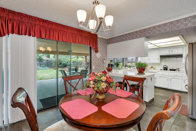 167 W Quincy Ave, Fresno, CA 93711 - dining space featuring a chandelier, wallpapered walls, a textured ceiling, and crown molding