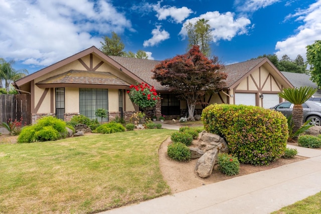 167 W Quincy Ave, Fresno, CA 93711 - view of front of home featuring a front lawn, a garage, stone siding, stucco siding, and fence