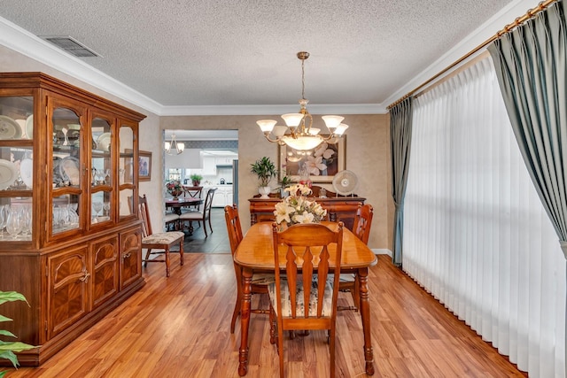 167 W Quincy Ave, Fresno, CA 93711 - dining area with light wood-style floors, visible vents, an inviting chandelier, and a textured ceiling