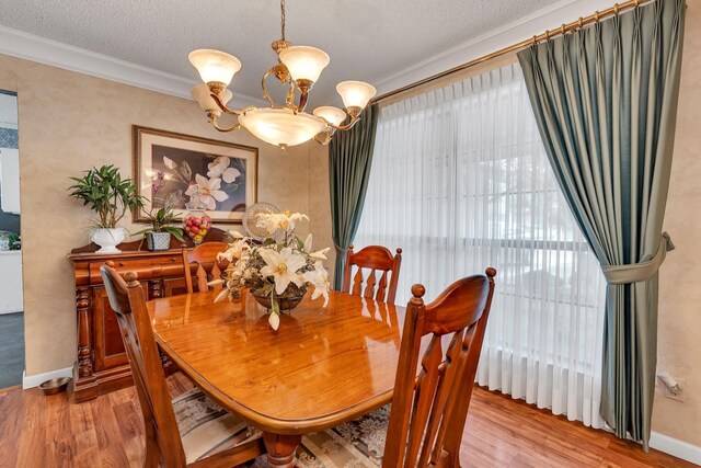 167 W Quincy Ave, Fresno, CA 93711 - dining area with wood finished floors, a chandelier, ornamental molding, and baseboards