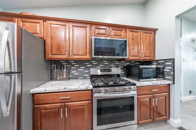 3336 N Lafayette Ave, Fresno, CA 93705 - kitchen featuring stainless steel appliances, backsplash, brown cabinets, and vaulted ceiling