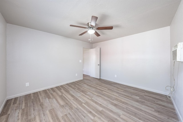 3336 N Lafayette Ave, Fresno, CA 93705 - unfurnished room with a ceiling fan, baseboards, an AC wall unit, and light wood-style floors