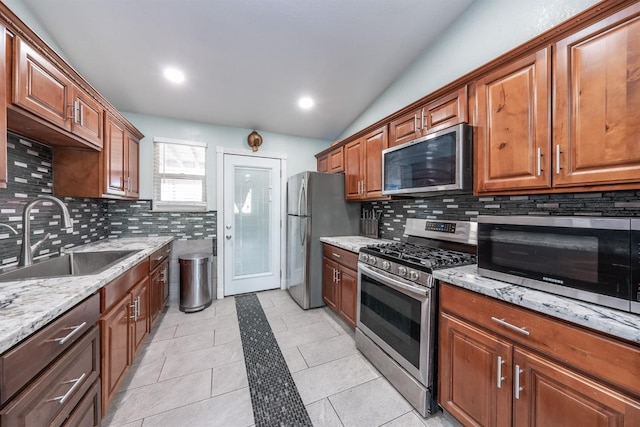 3336 N Lafayette Ave, Fresno, CA 93705 - kitchen featuring light stone counters, a sink, appliances with stainless steel finishes, and decorative backsplash