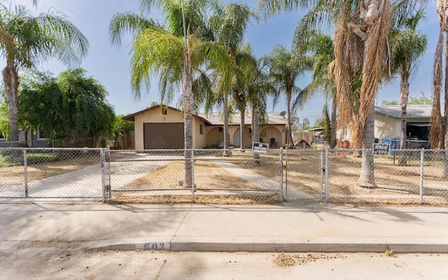 603 E Compton Ave, Pixley, CA 93256 - view of front facade featuring driveway, a fenced front yard, a gate, stucco siding, and a garage