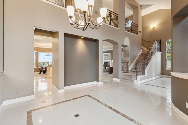 4918 W Bluff Ave, Fresno, CA 93722 - tiled entrance foyer featuring stairs, baseboards, arched walkways, a notable chandelier, and a high ceiling