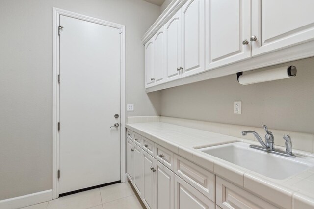 4918 W Bluff Ave, Fresno, CA 93722 - clothes washing area featuring light tile patterned floors, baseboards, and a sink