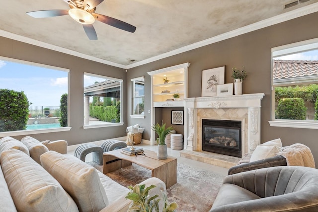 4918 W Bluff Ave, Fresno, CA 93722 - living room with a tiled fireplace, visible vents, a ceiling fan, and crown molding