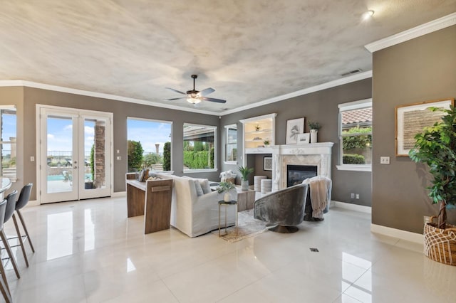4918 W Bluff Ave, Fresno, CA 93722 - living room with ceiling fan, baseboards, a glass covered fireplace, ornamental molding, and french doors