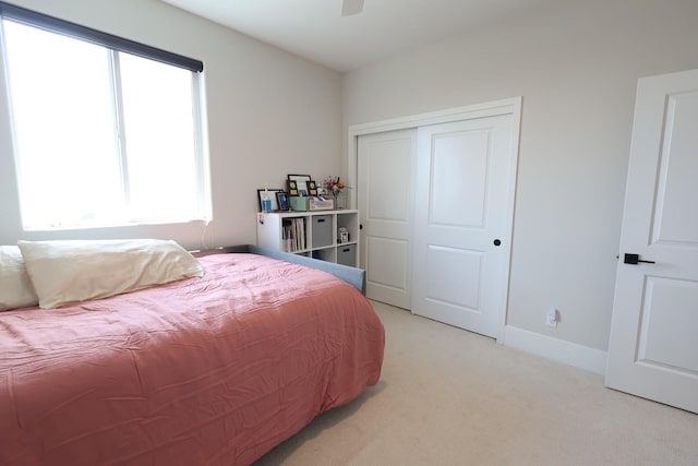 bedroom featuring a closet and light carpet