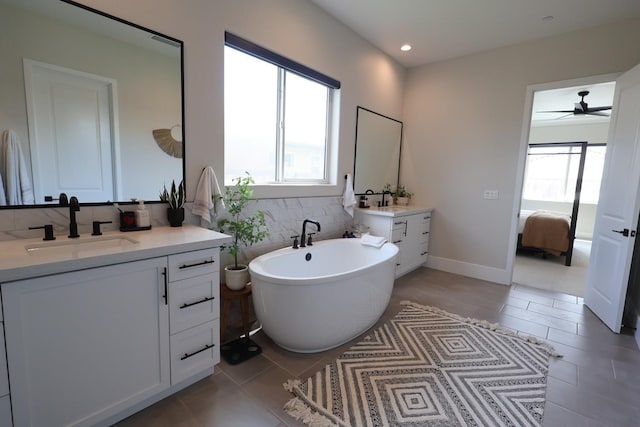 ensuite bathroom with a sink, connected bathroom, a ceiling fan, a freestanding bath, and tile patterned flooring