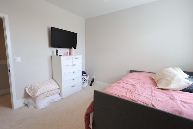 bedroom featuring baseboards and light carpet