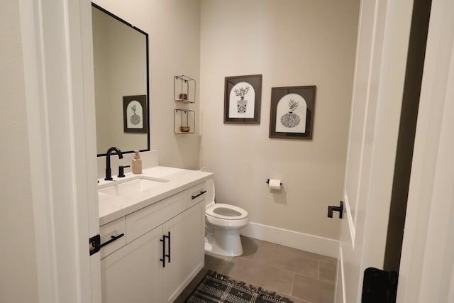 bathroom featuring baseboards, tile patterned floors, toilet, and vanity
