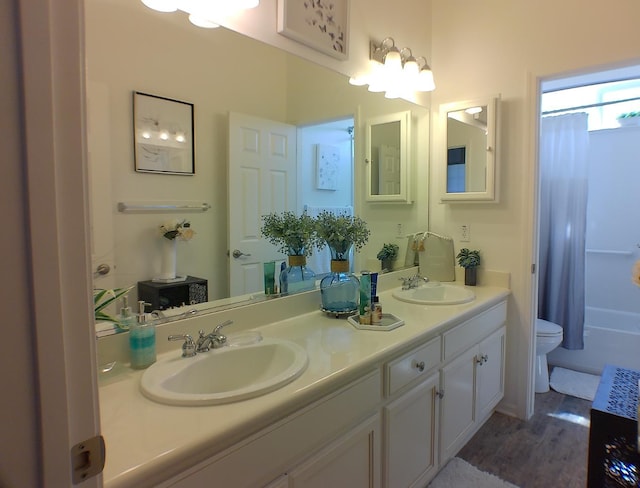 14335 Spyglass Cir, Chowchilla, CA 93610 - bathroom featuring double vanity, toilet, shower / bath combo, and wood finished floors