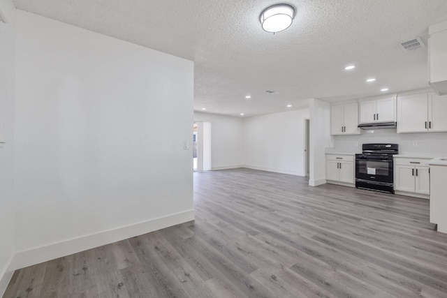 465 W Woods Ave, Tipton, CA 93272 - kitchen featuring a textured ceiling, white cabinets, baseboards, black range with gas stovetop, and light wood finished floors