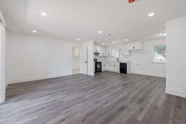 465 W Woods Ave, Tipton, CA 93272 - unfurnished living room with baseboards, recessed lighting, wood finished floors, and a textured ceiling