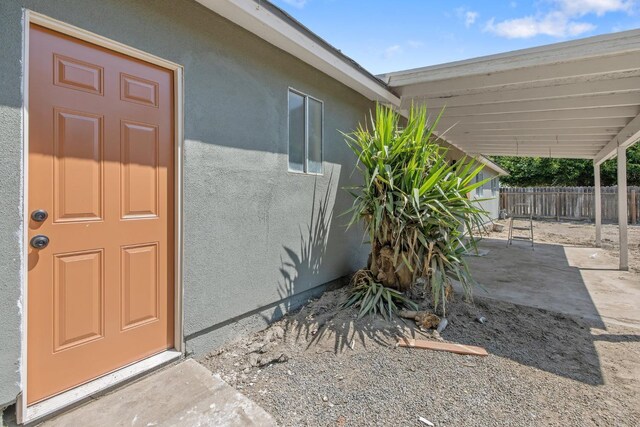 465 W Woods Ave, Tipton, CA 93272 - entrance to property featuring a patio, stucco siding, and fence