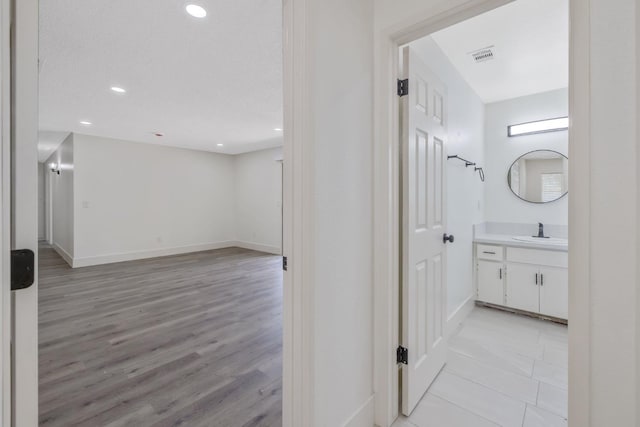 465 W Woods Ave, Tipton, CA 93272 - hallway featuring recessed lighting, a sink, light wood-style floors, visible vents, and baseboards