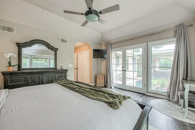bedroom with access to outside, visible vents, wood finished floors, and vaulted ceiling
