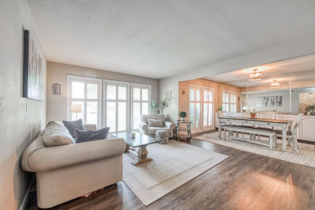 living room featuring a textured ceiling and dark wood-style floors