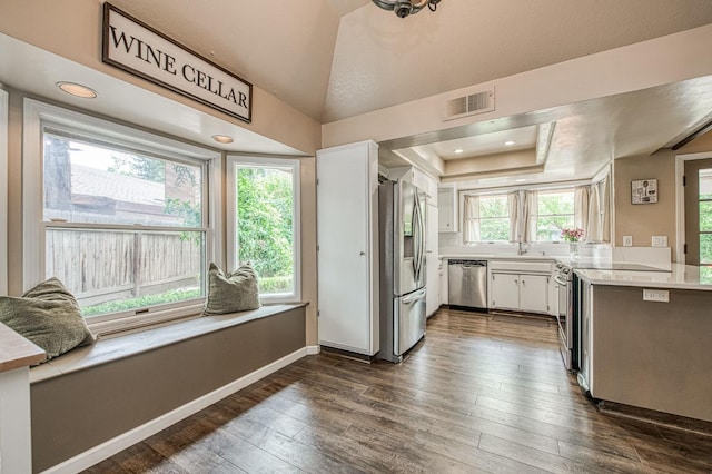 kitchen with light countertops, stainless steel appliances, white cabinetry, dark wood-type flooring, and visible vents