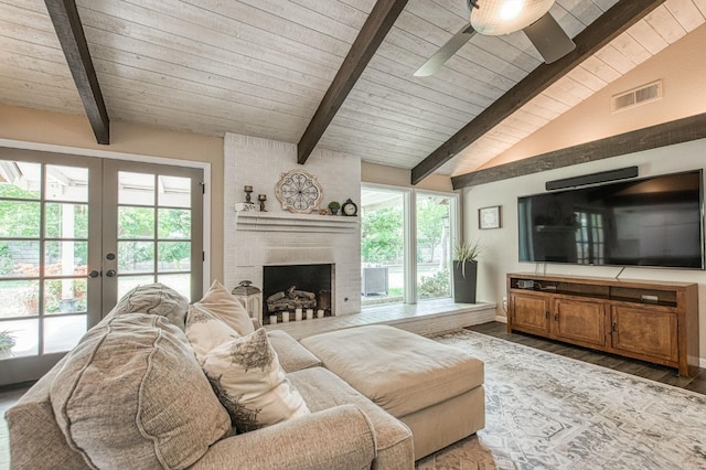 living area with visible vents, wood ceiling, a wealth of natural light, and vaulted ceiling with beams