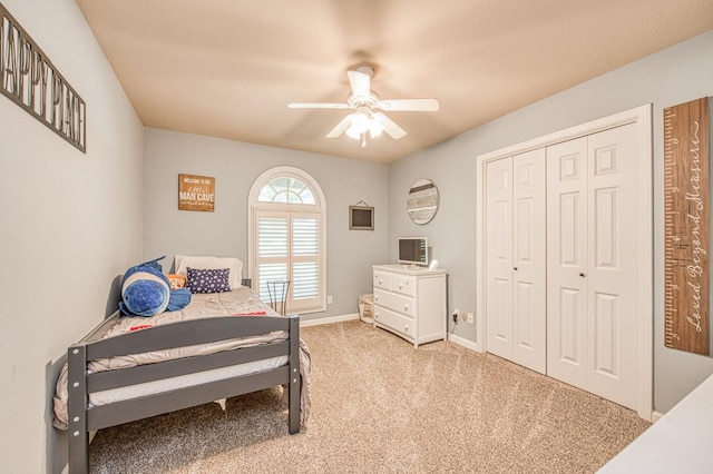 carpeted bedroom featuring ceiling fan, baseboards, and a closet