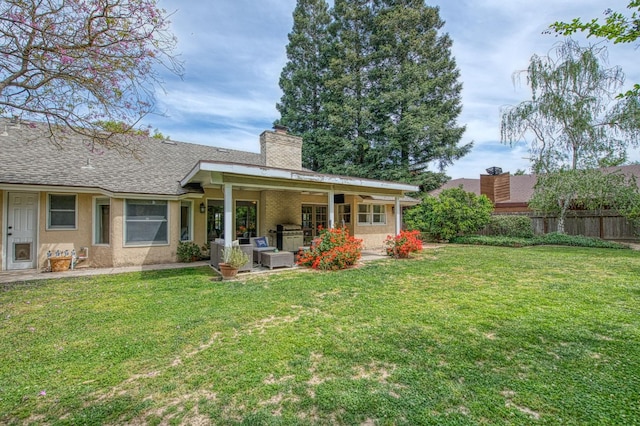 back of property featuring a lawn, fence, a chimney, and outdoor lounge area