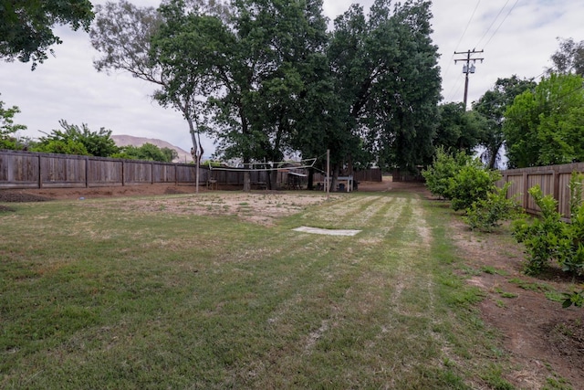 view of yard featuring a fenced backyard and a mountain view