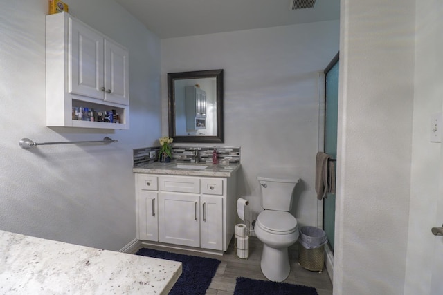 full bath with vanity, toilet, baseboards, wood finished floors, and an enclosed shower