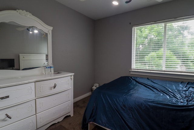 bedroom featuring baseboards and dark carpet