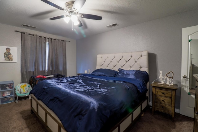 carpeted bedroom with visible vents, a textured wall, and ceiling fan