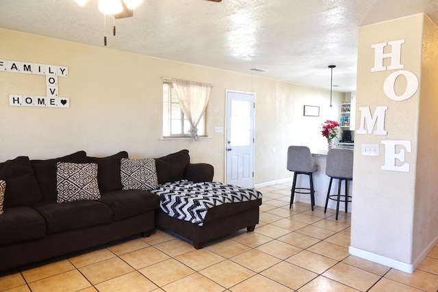 215 W Vine Ave, Visalia, CA 93291 - living area with baseboards, a textured ceiling, ceiling fan, and light tile patterned floors