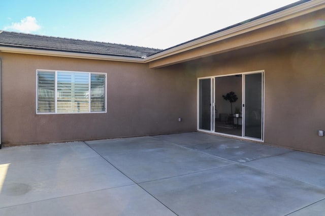 rear view of house with a patio and stucco siding