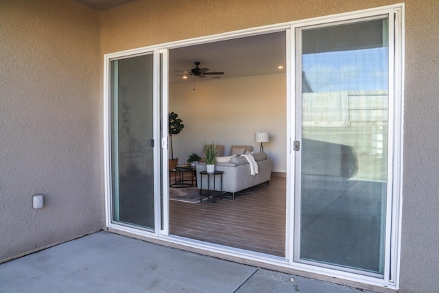 view of exterior entry featuring stucco siding and a patio area