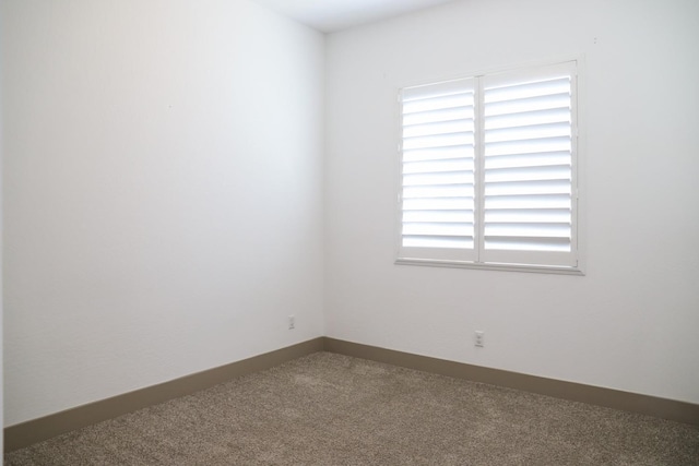 unfurnished room featuring carpet floors and baseboards