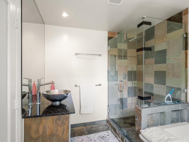 full bathroom with vanity, visible vents, stone tile flooring, and a shower stall