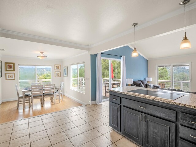 kitchen with crown molding, light tile patterned floors, black electric stovetop, and decorative light fixtures