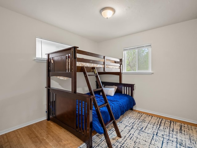 bedroom with baseboards and wood finished floors