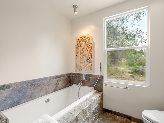 bathroom featuring toilet and a garden tub