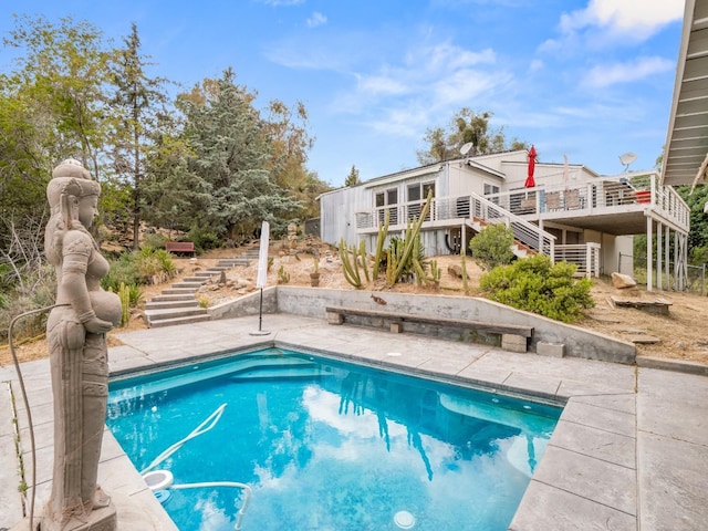 pool featuring stairway, a deck, and a patio area
