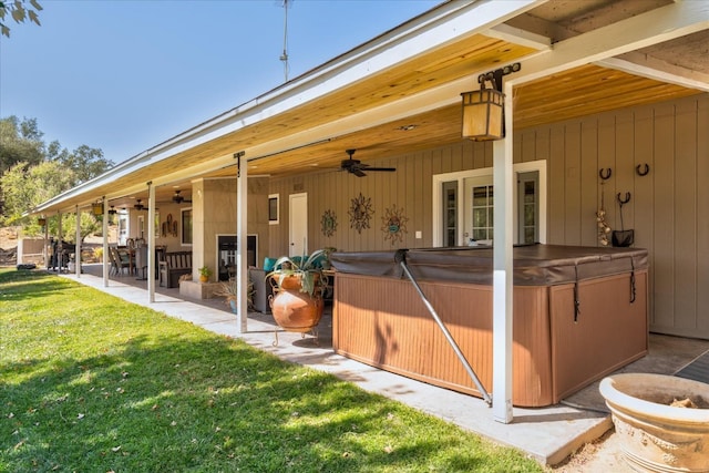 back of property with a yard, a patio, ceiling fan, and a hot tub