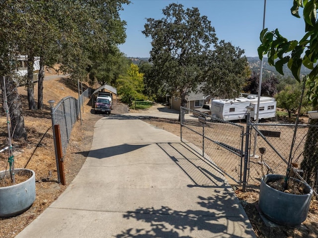 view of street with a gate, a gated entry, and driveway