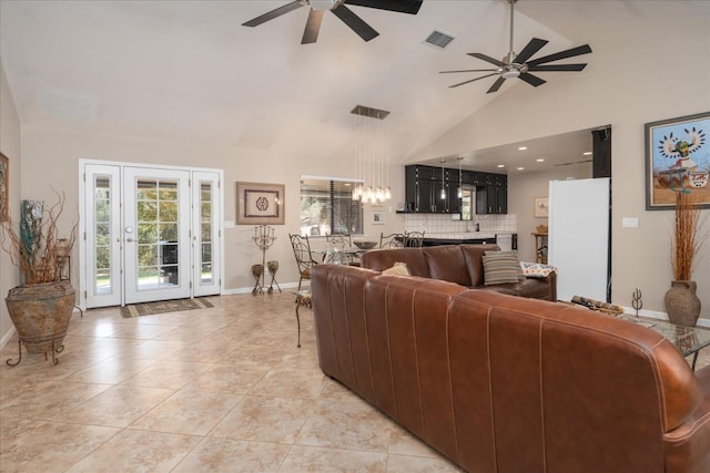 living area with baseboards, visible vents, ceiling fan with notable chandelier, and high vaulted ceiling