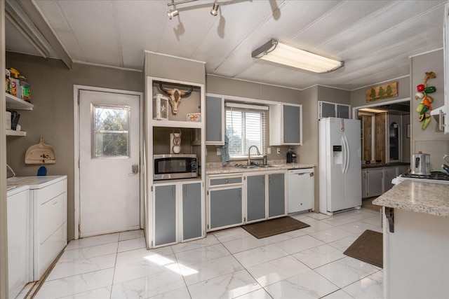 kitchen with open shelves, marble finish floor, washer and dryer, white appliances, and a sink