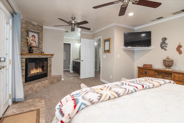 carpeted bedroom with visible vents, ornamental molding, baseboards, and a fireplace