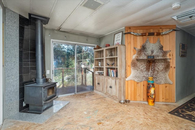 living area with visible vents and a wood stove