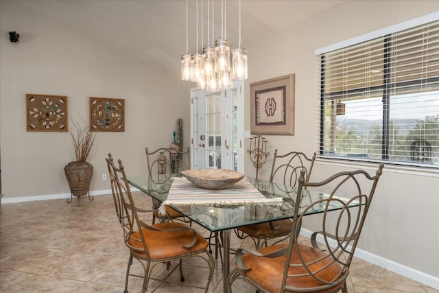 dining area with an inviting chandelier, baseboards, and vaulted ceiling