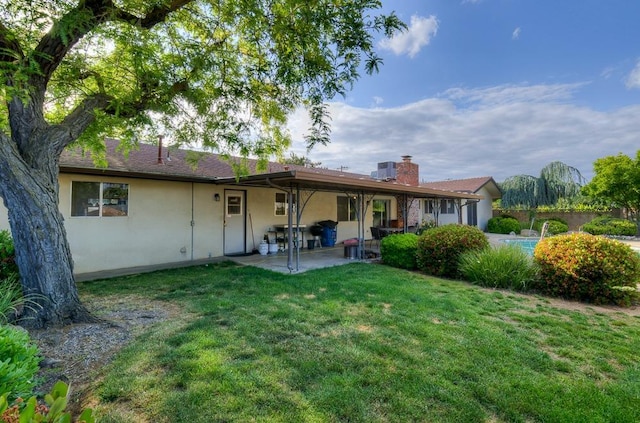 827 N Armstrong Ave, Clovis, CA 93611 - rear view of property featuring a patio, stucco siding, a lawn, and a chimney
